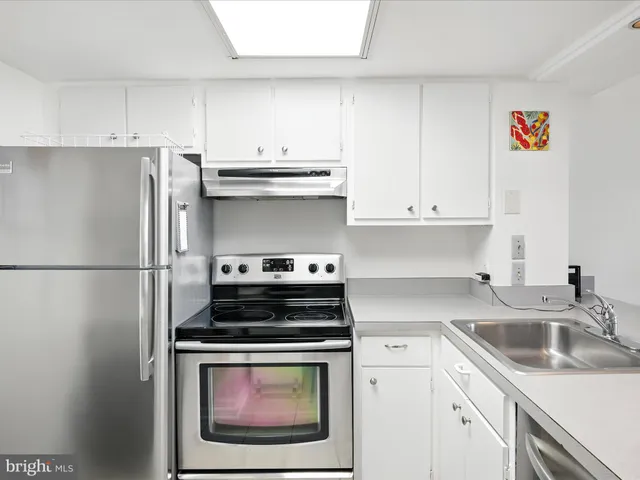 a kitchen with stainless steel appliances granite countertop a refrigerator stove and sink