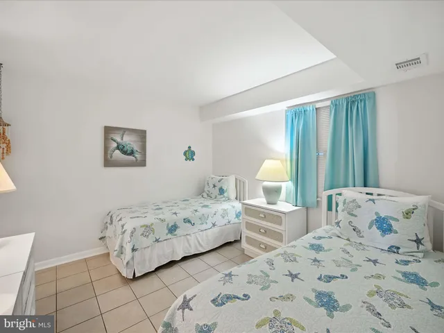 a bedroom with two beds and painting on the wall