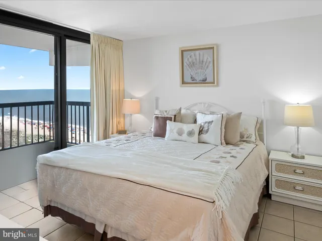 a large white bed sitting in a bedroom next to a window