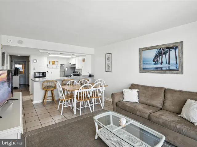 a living room with furniture and a view of kitchen
