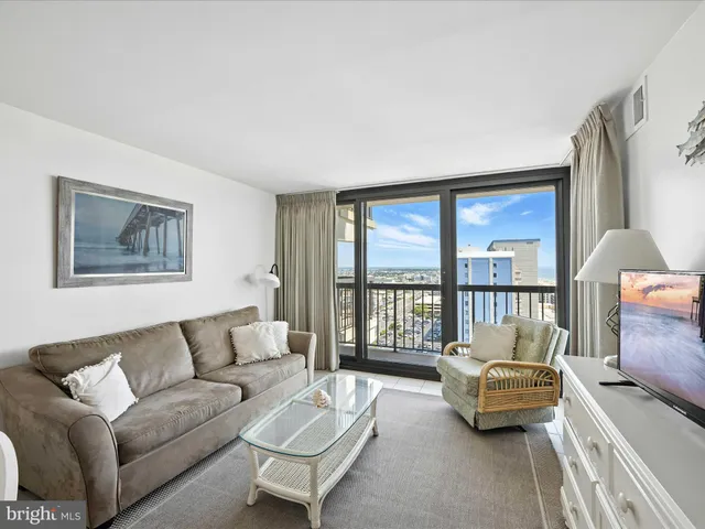 a living room with furniture and a floor to ceiling window