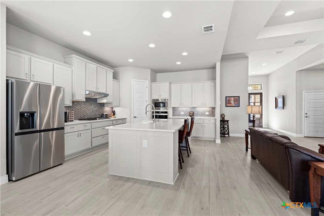477 Vamanos Boerne, TX 78006 - Photo 11 of 29 a kitchen with refrigerator cabinets and wooden floor
