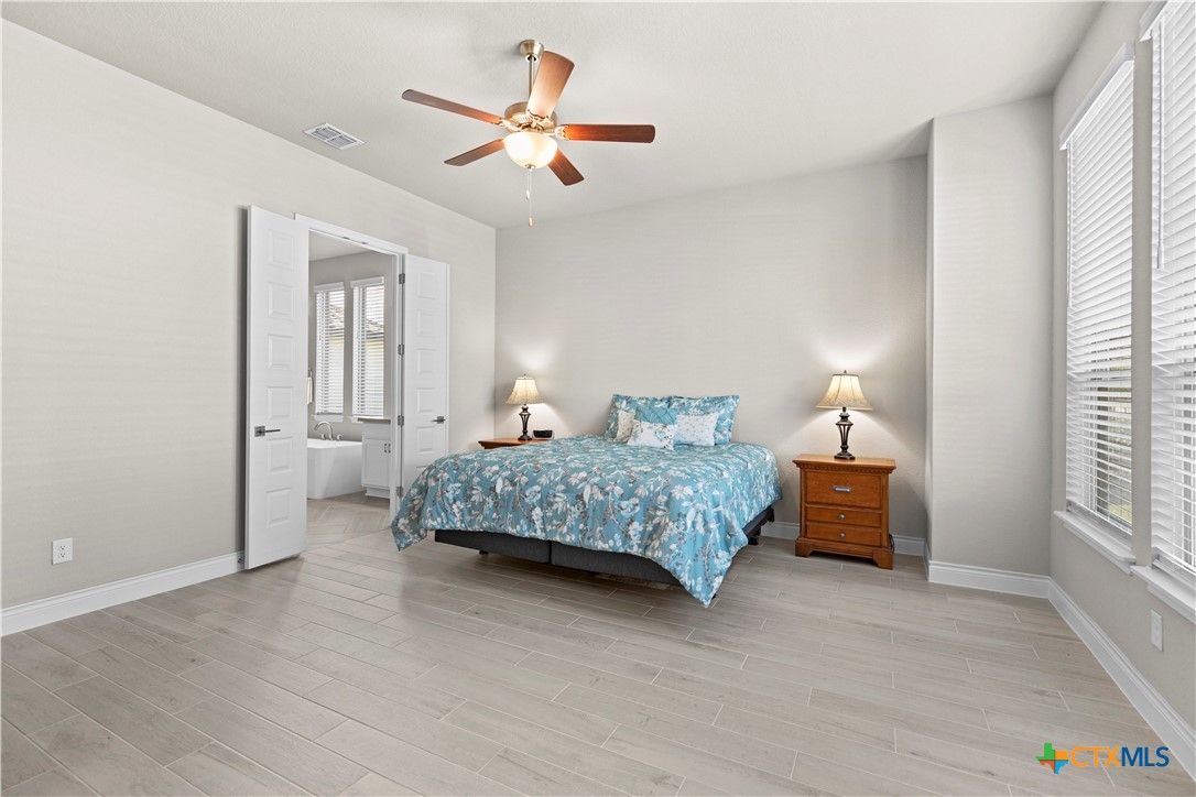 477 Vamanos Boerne, TX 78006 - Photo 14 of 29 a bedroom with a bed and a chandelier