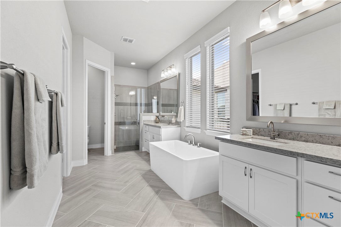 477 Vamanos Boerne, TX 78006 - Photo 17 of 29 a large white bathroom with a granite countertop sink mirror and bathtub
