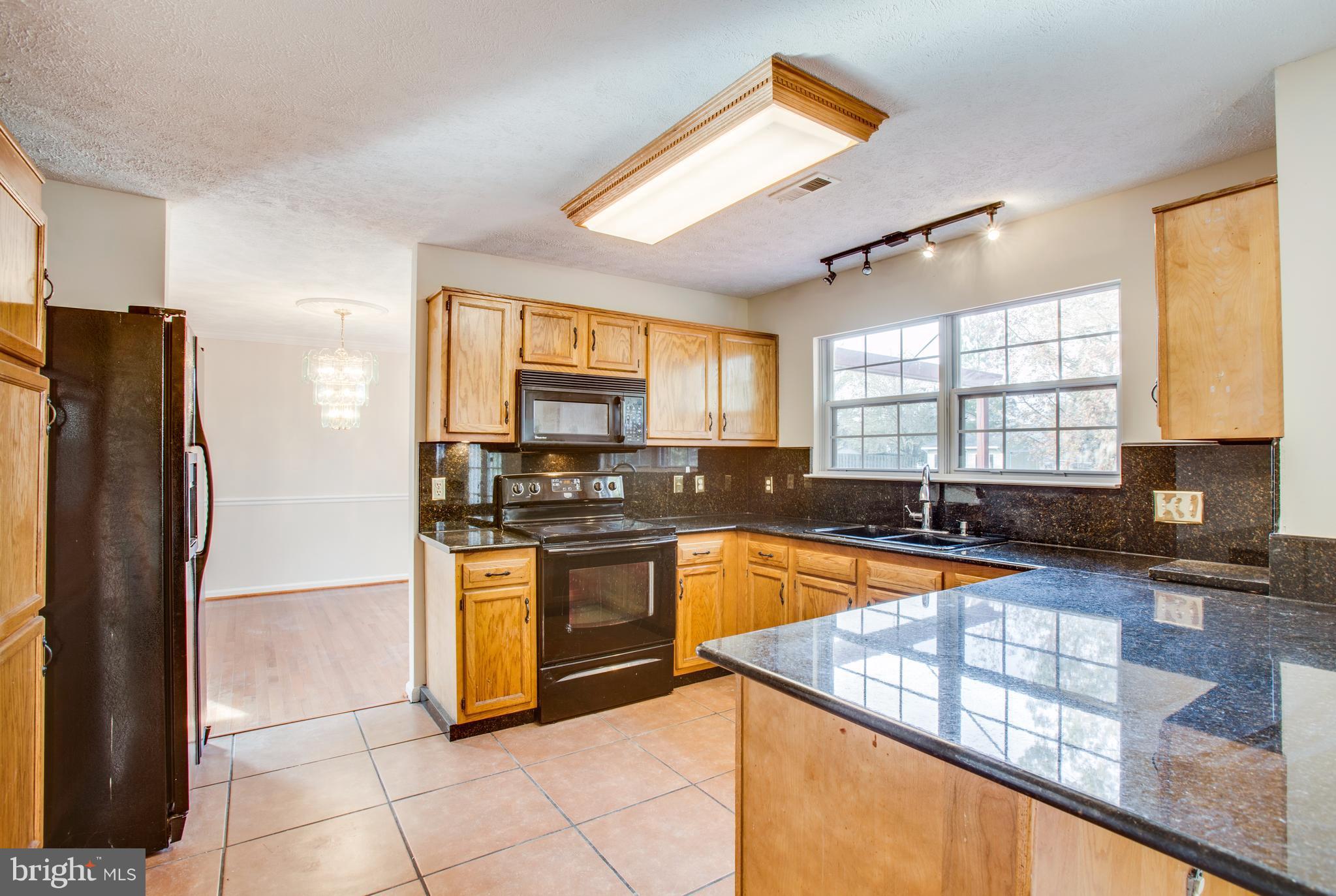 5 Wells Road Stafford, VA 22556 - Photo 8 of 28 a kitchen with stainless steel appliances granite countertop a stove a sink and a refrigerator