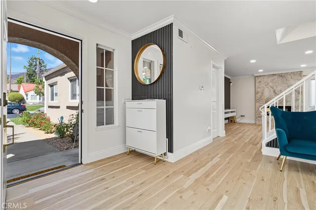 a view of a hallway with wooden floor and a bathroom