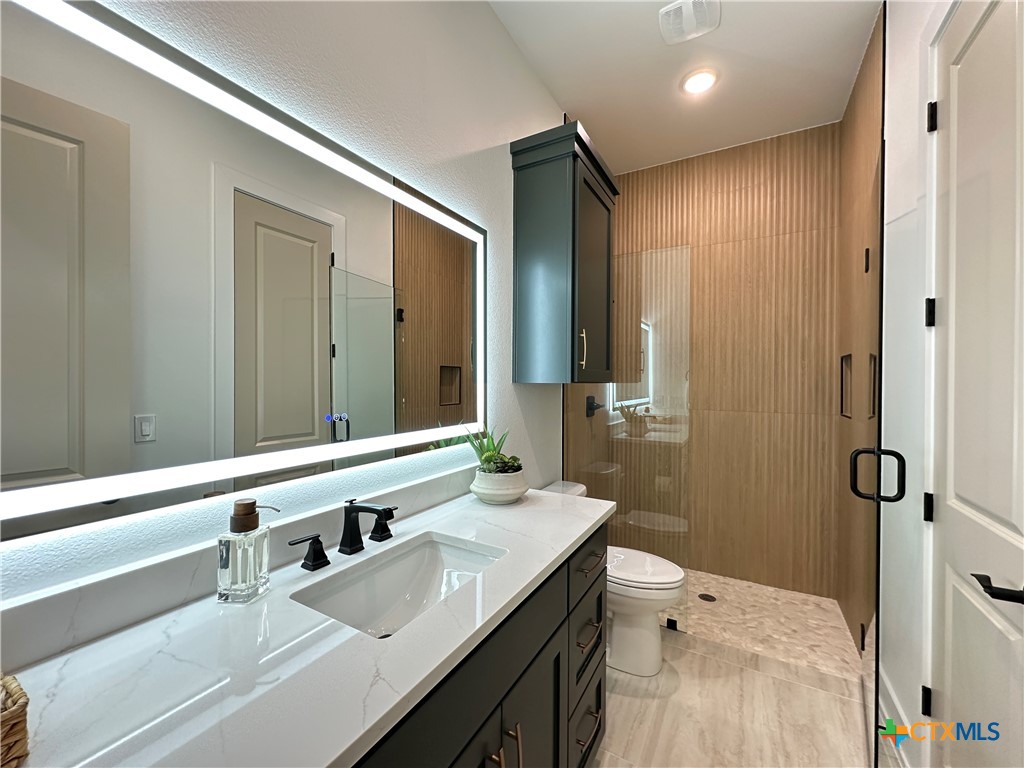 430 Dos Rios Drive Belton, TX 76513 - Photo 31 of 48 a bathroom with a granite countertop sink a toilet and shower