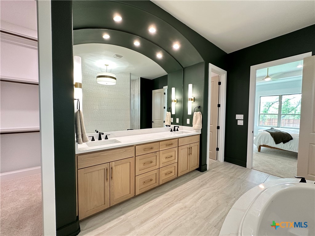 430 Dos Rios Drive Belton, TX 76513 - Photo 42 of 48 a en suite bathroom with a double vanity sink a large mirror and a shower