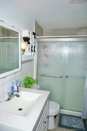 a bathroom with a sink a toilet and shower