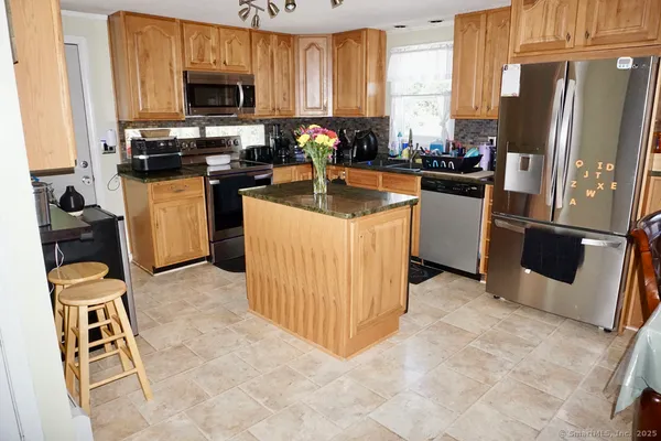 a kitchen with stainless steel appliances a stove refrigerator sink and microwave