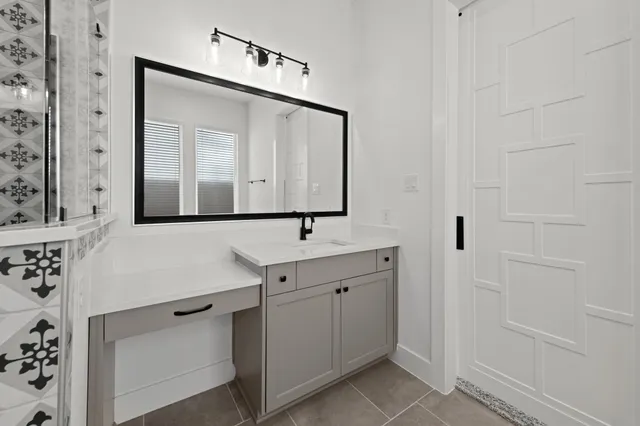 a bathroom with a sink a mirror and vanity