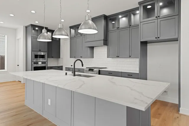 a kitchen with kitchen island a sink stainless steel appliances and cabinets