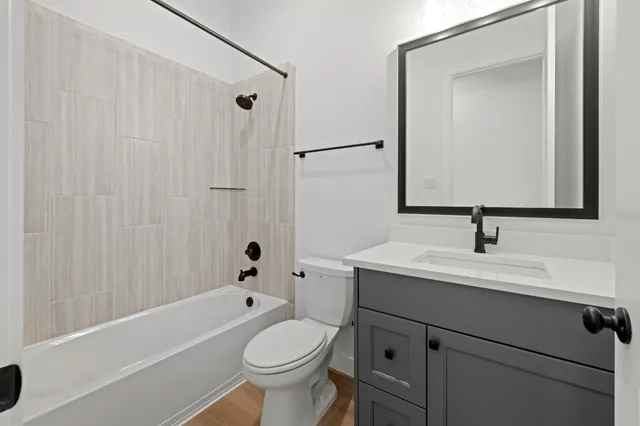 a bathroom with a sink a toilet and shower