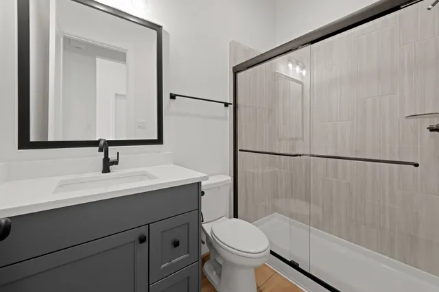 a bathroom with a sink a toilet and shower