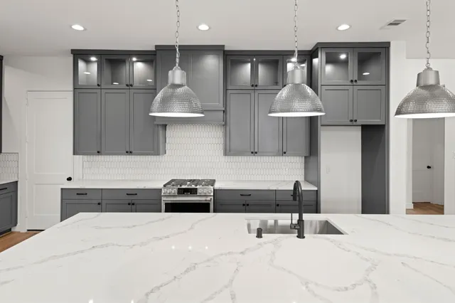 a kitchen with stainless steel appliances kitchen island sink refrigerator and stove