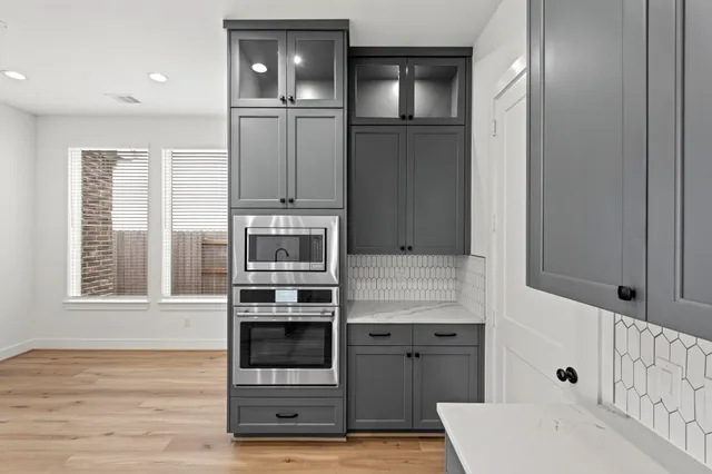a kitchen with stainless steel appliances cabinets and wooden floor