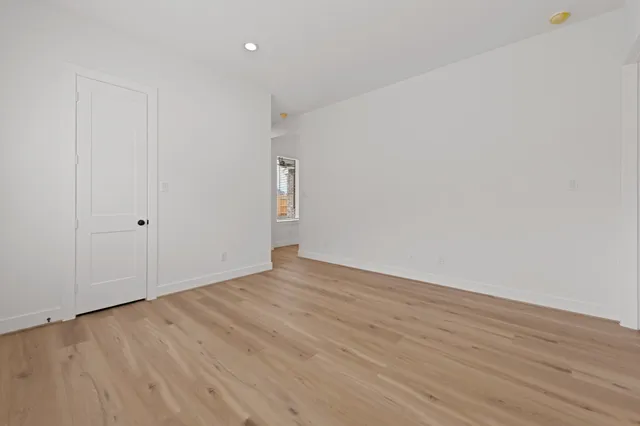 a view of an empty room with wooden floor
