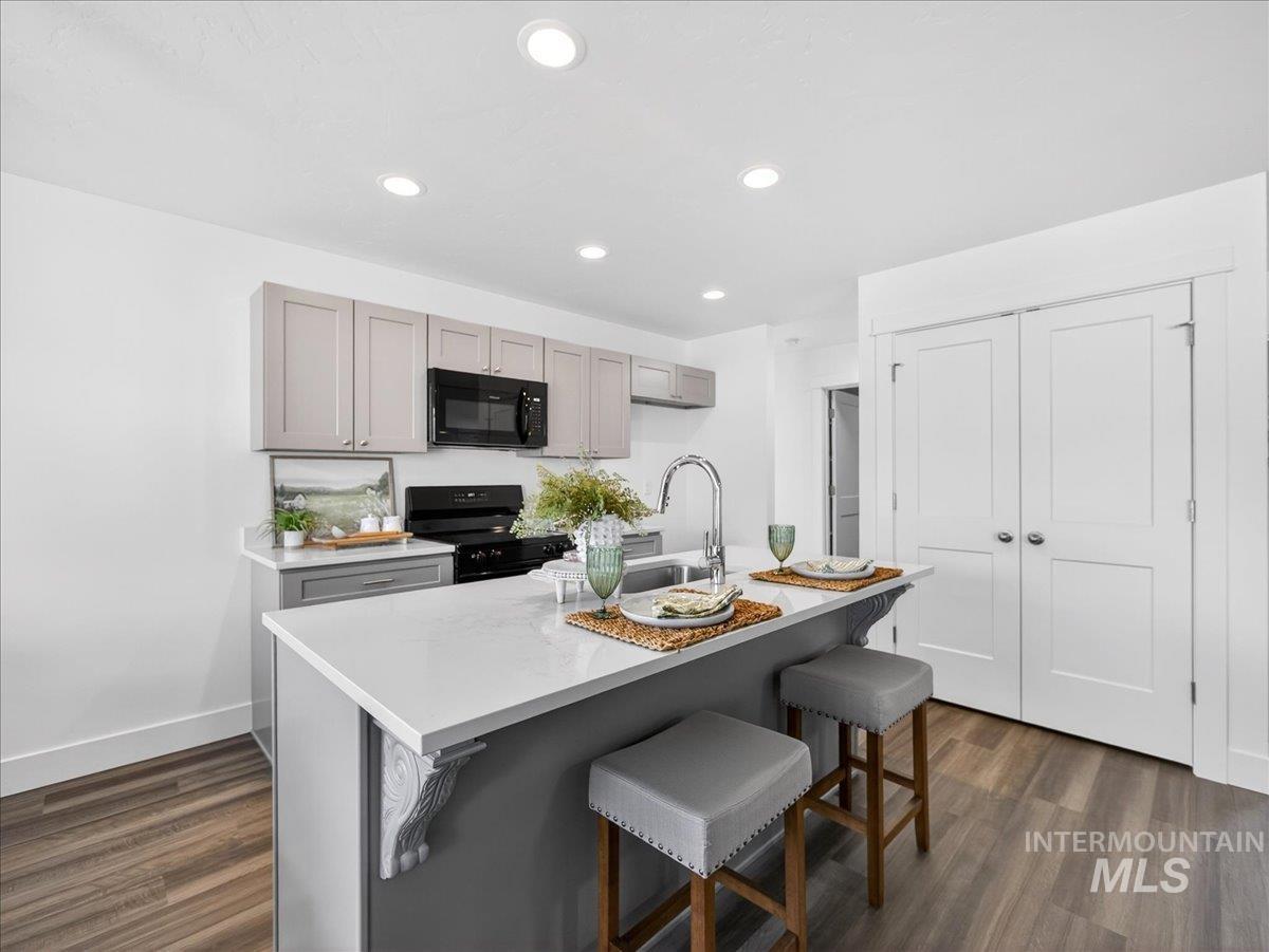 1410 Regency Way Emmett, ID 83617 - Photo 11 of 46 Kitchen with gray cabinetry, a breakfast bar area, a kitchen island with sink, and recessed lighting