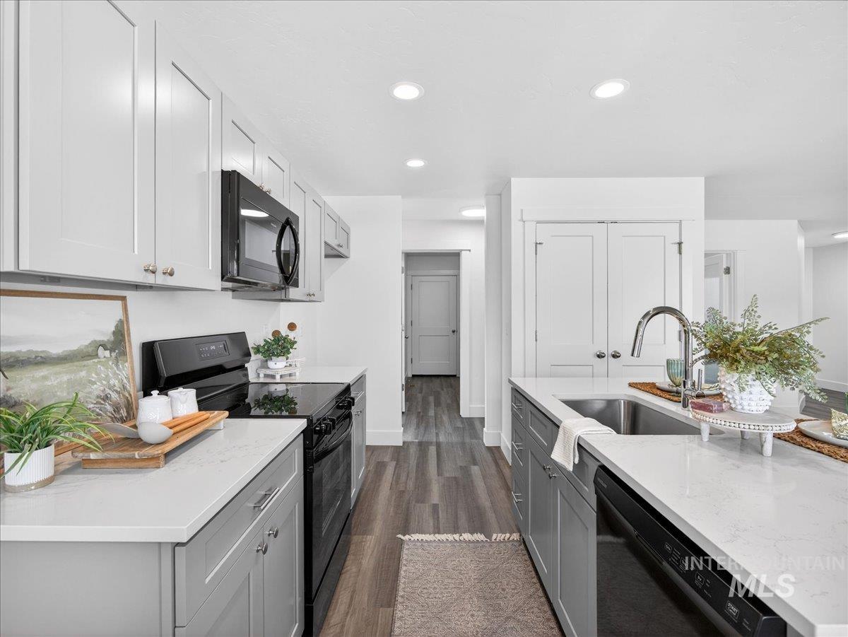 1410 Regency Way Emmett, ID 83617 - Photo 12 of 46 Kitchen with black appliances, light stone countertops, dark wood-type flooring, gray cabinetry, and recessed lighting