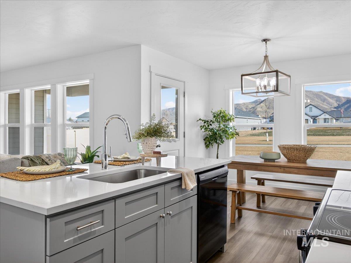 1410 Regency Way Emmett, ID 83617 - Photo 13 of 46 Kitchen featuring gray cabinetry, black appliances, dark wood-type flooring, and light stone counters