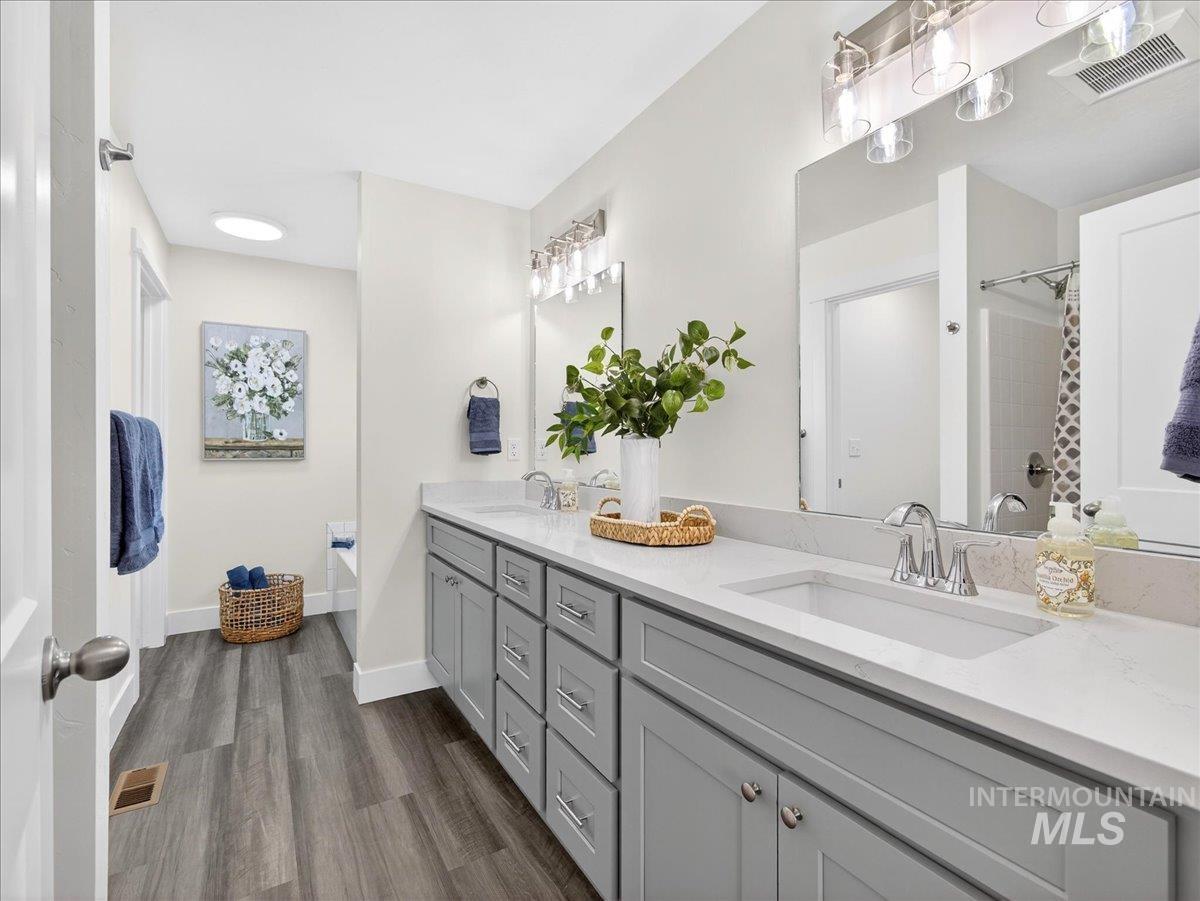 1410 Regency Way Emmett, ID 83617 - Photo 21 of 46 Bathroom with double vanity, dark wood-style flooring, and a shower