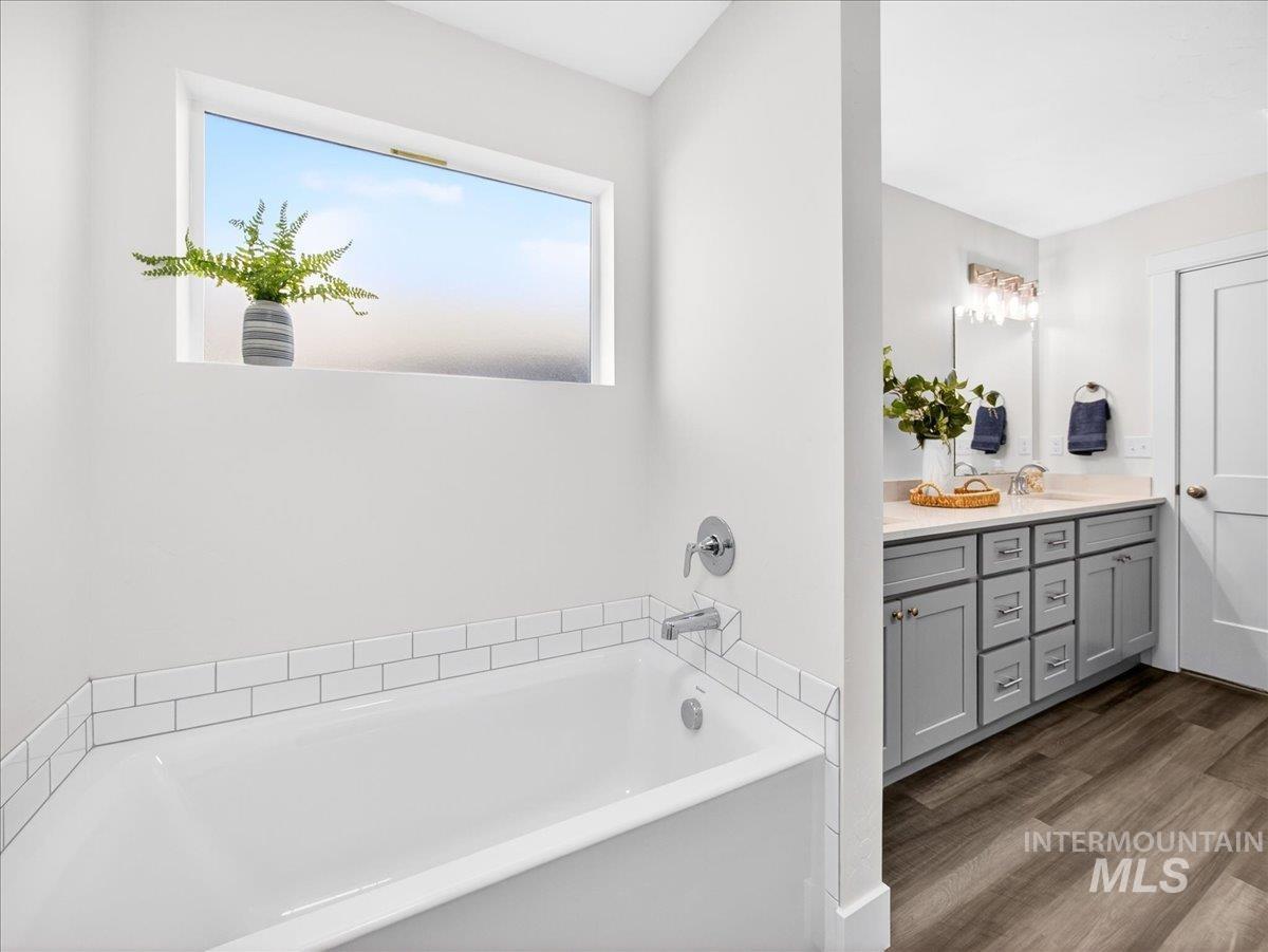 1410 Regency Way Emmett, ID 83617 - Photo 24 of 46 Bathroom featuring vanity, a bath, and dark wood-style floors