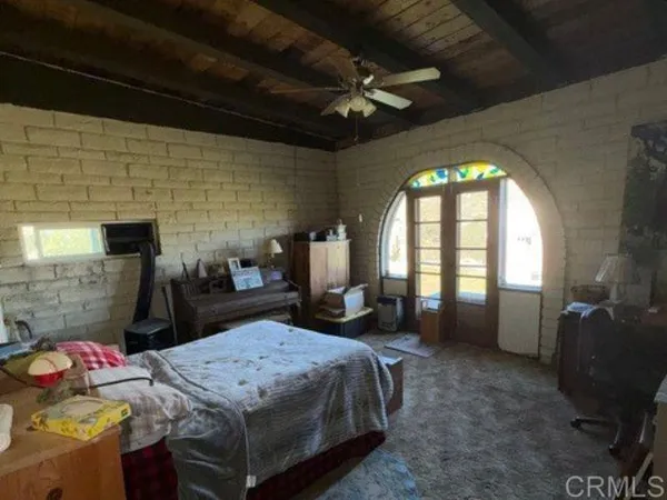 a bedroom with a bed a dresser next to a window