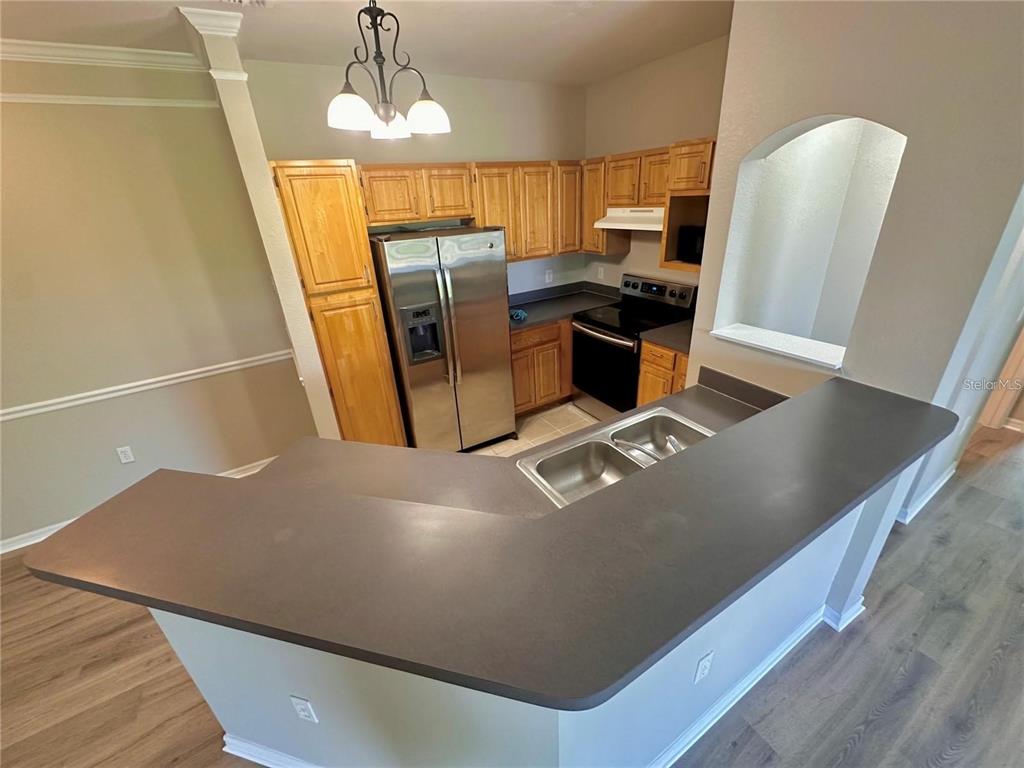 3280 Soho Street, Unit 307 Orlando, FL 32835 - Photo 9 of 34 a view of a kitchen with fridge and wooden floor