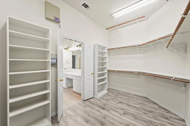 a view of walk in closet with empty racks