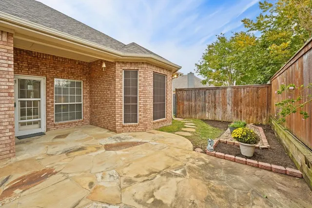 a view of backyard with table and chairs and wooden fence