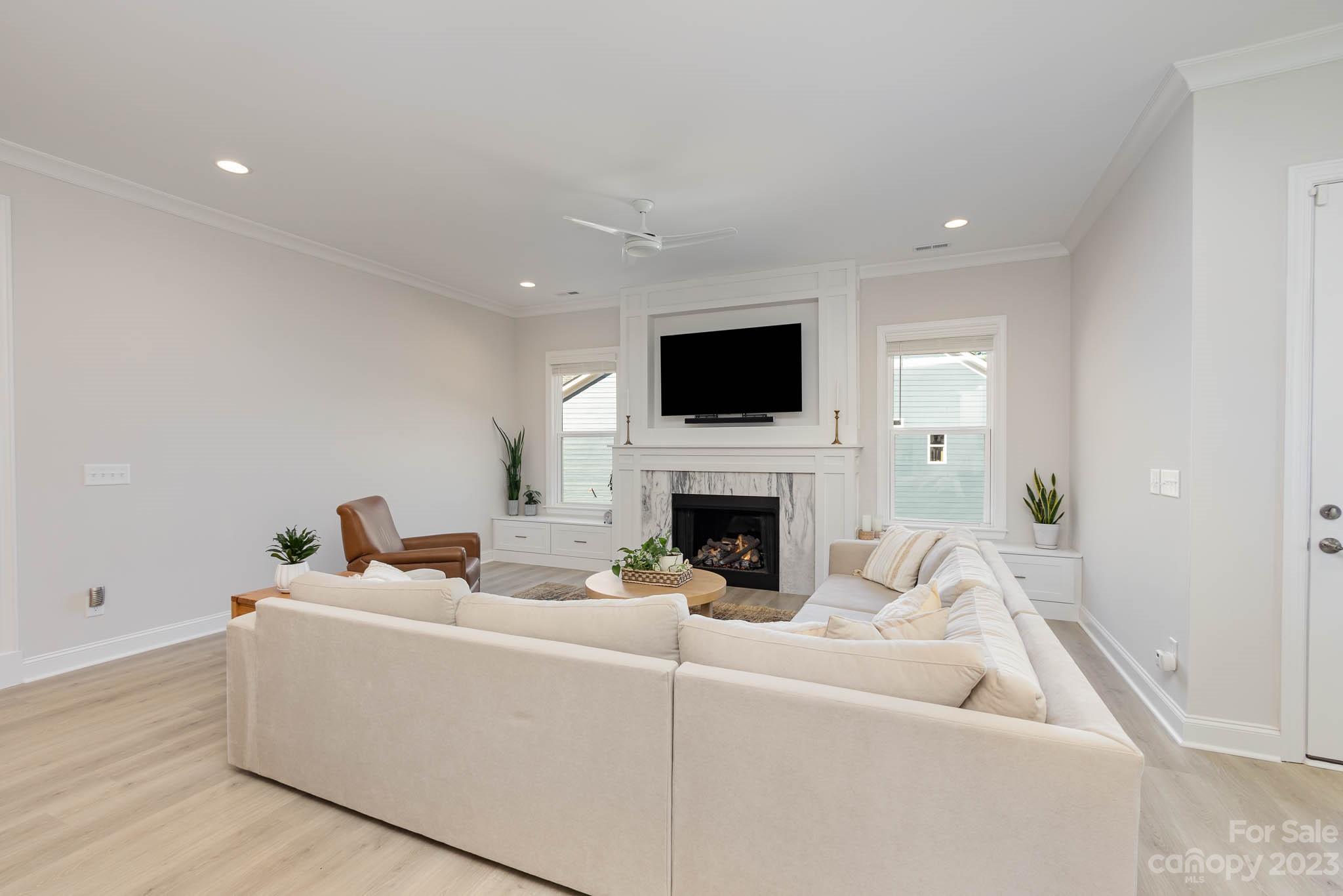 17150 Sand Bank Road Charlotte, NC 28278 - Photo 10 of 32 a living room with furniture a fireplace and a flat screen tv
