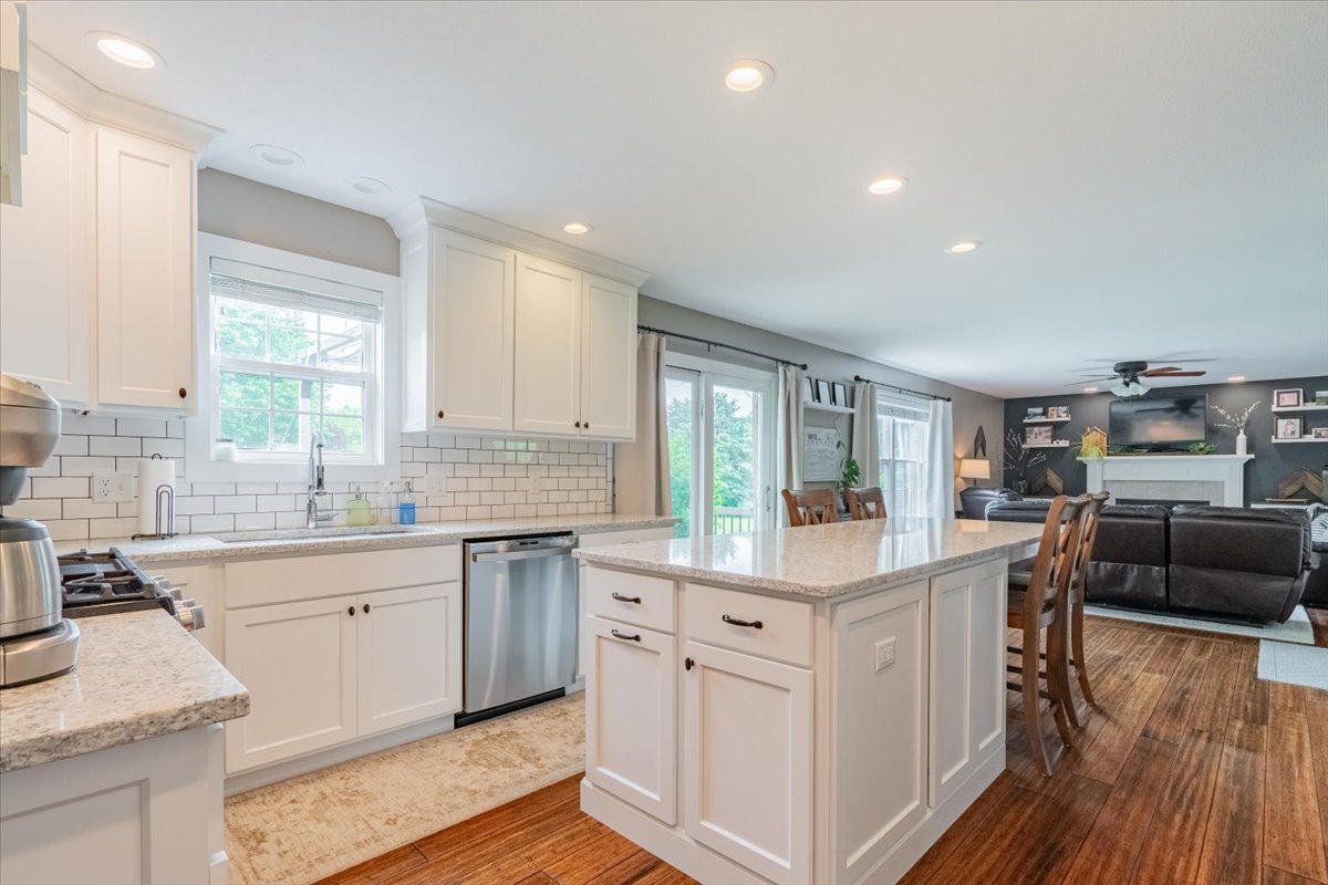 13561 Buck Road Bloomington, IL 61705 - Photo 11 of 43 a kitchen with stainless steel appliances granite countertop a white cabinets and wooden floors