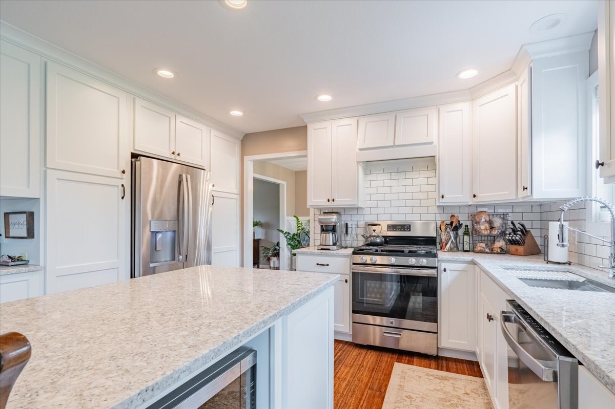 13561 Buck Road Bloomington, IL 61705 - Photo 15 of 43 a kitchen with stainless steel appliances granite countertop a sink stove microwave and refrigerator