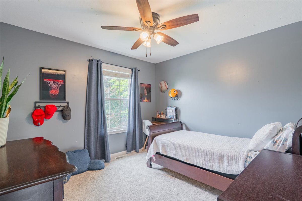 13561 Buck Road Bloomington, IL 61705 - Photo 25 of 43 a bedroom with a bed and a chandelier