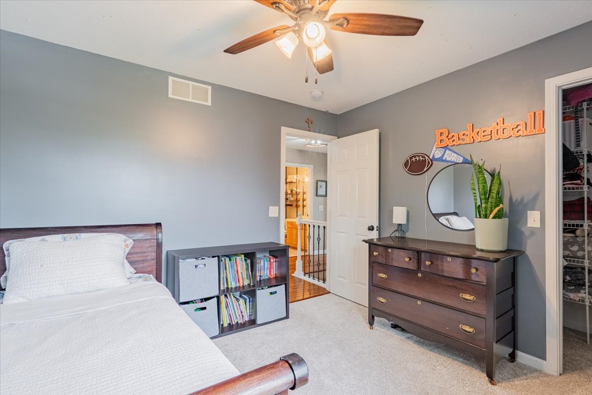 13561 Buck Road Bloomington, IL 61705 - Photo 26 of 43 a bedroom with a bed and a chandelier