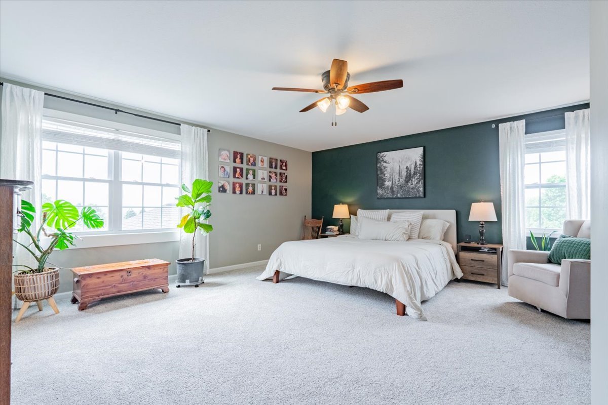 13561 Buck Road Bloomington, IL 61705 - Photo 28 of 43 a spacious bedroom with a bed couch and a potted plant