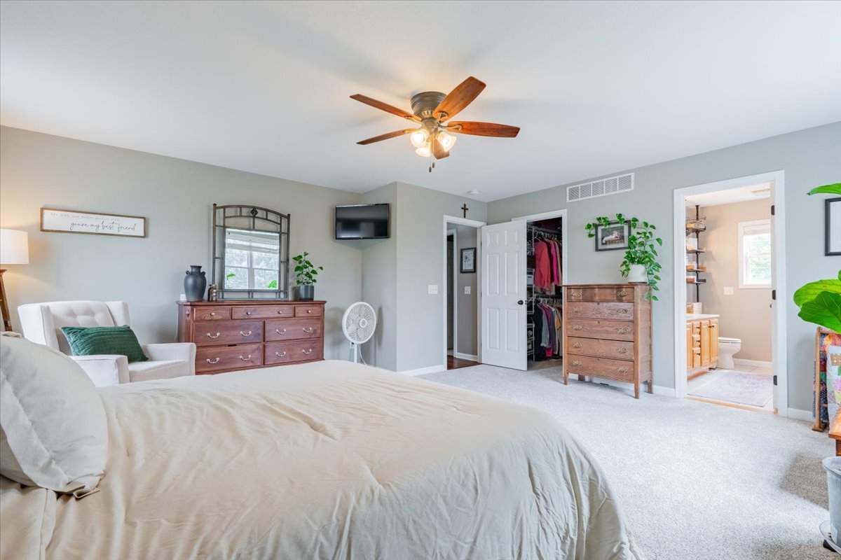 13561 Buck Road Bloomington, IL 61705 - Photo 30 of 43 a bedroom with a large bed and a chandelier