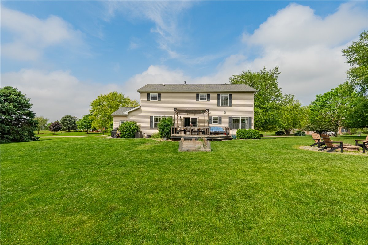 13561 Buck Road Bloomington, IL 61705 - Photo 41 of 43 a view of a white house in front of a big yard with plants and large trees