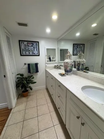a large white kitchen with a sink and a large mirror