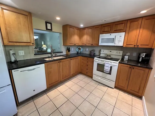 a kitchen with stainless steel appliances a sink stove refrigerator and cabinets