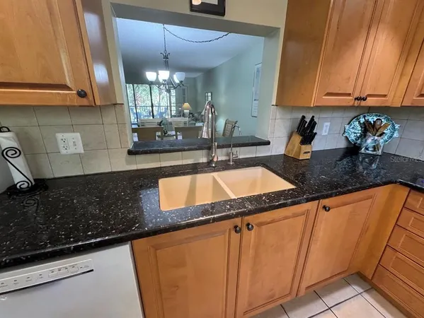 a kitchen with granite countertop a sink a stove and cabinets