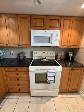 a kitchen with granite countertop cabinets stainless steel appliances and a sink