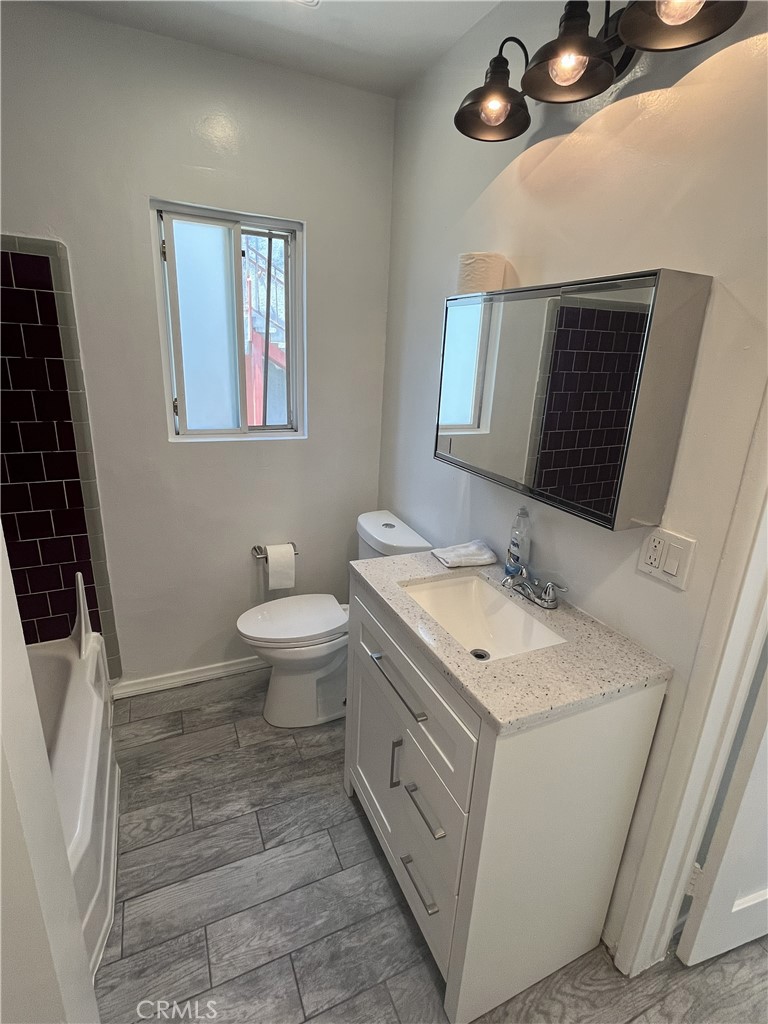 3112 Washington Boulevard Venice, CA 90291 - Photo 12 of 13 a spacious bathroom with a granite countertop sink a toilet and a mirror