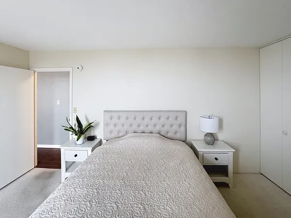 a bedroom with a bed and a potted plant