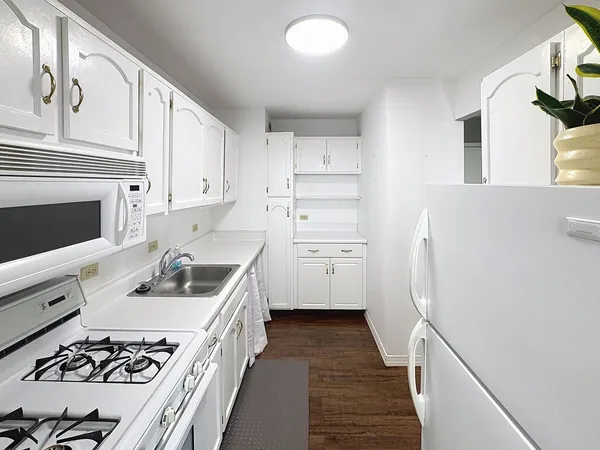 a kitchen with a sink stove top oven and cabinets