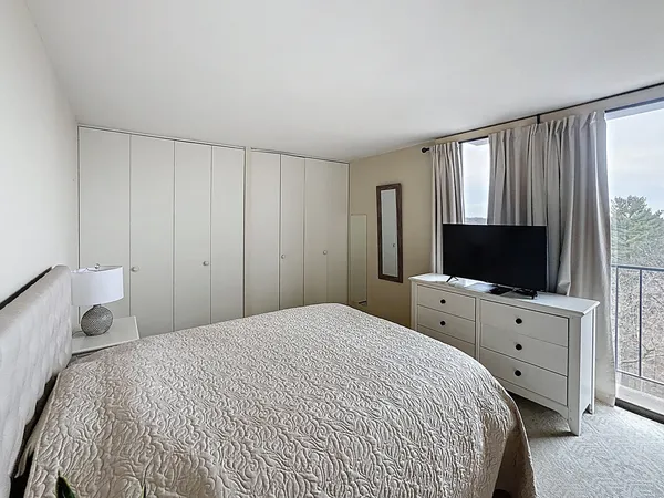 a bedroom with a bed and a flat screen tv