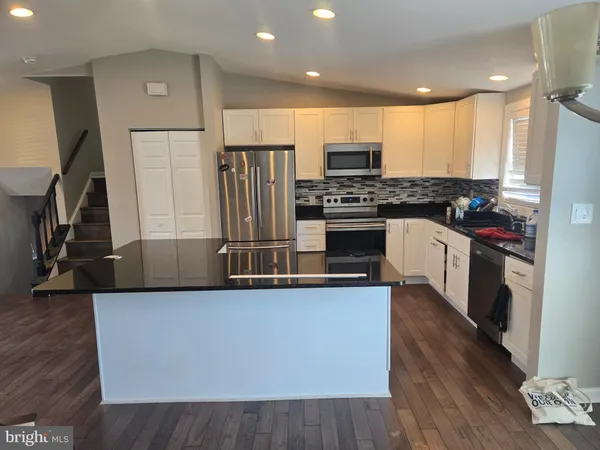 a kitchen with stainless steel appliances a refrigerator a stove a sink and a center