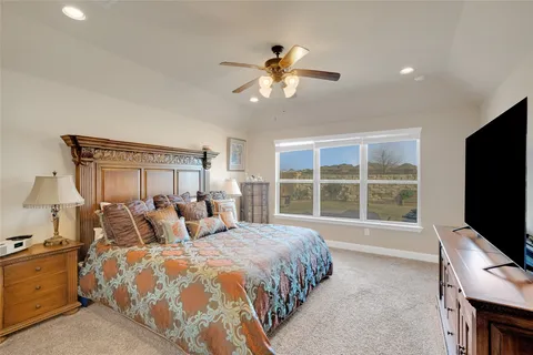a bedroom with a bed and a flat tv screen on dresser