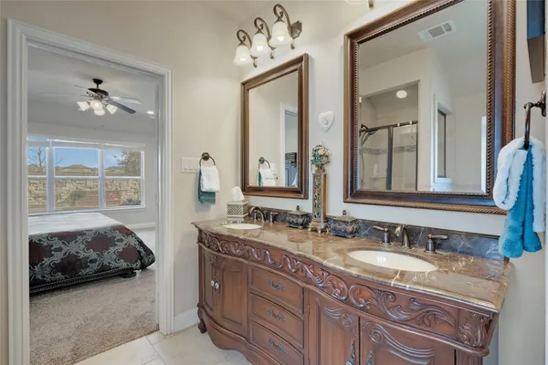 a en suite bathroom with a double vanity sink and a mirror