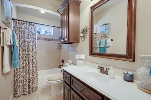 a bathroom with a granite countertop toilet sink and mirror